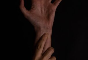 Two hands reaching out in darkness